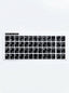 Plan rapproché sur des stickers clavier arabe et AZERTY appliqués sur un ordinateur portable.