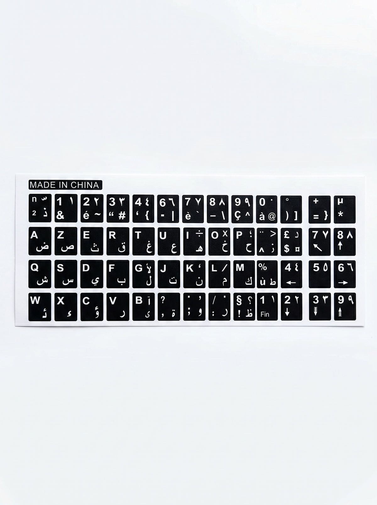 Plan rapproché sur des stickers clavier arabe et AZERTY appliqués sur un ordinateur portable.