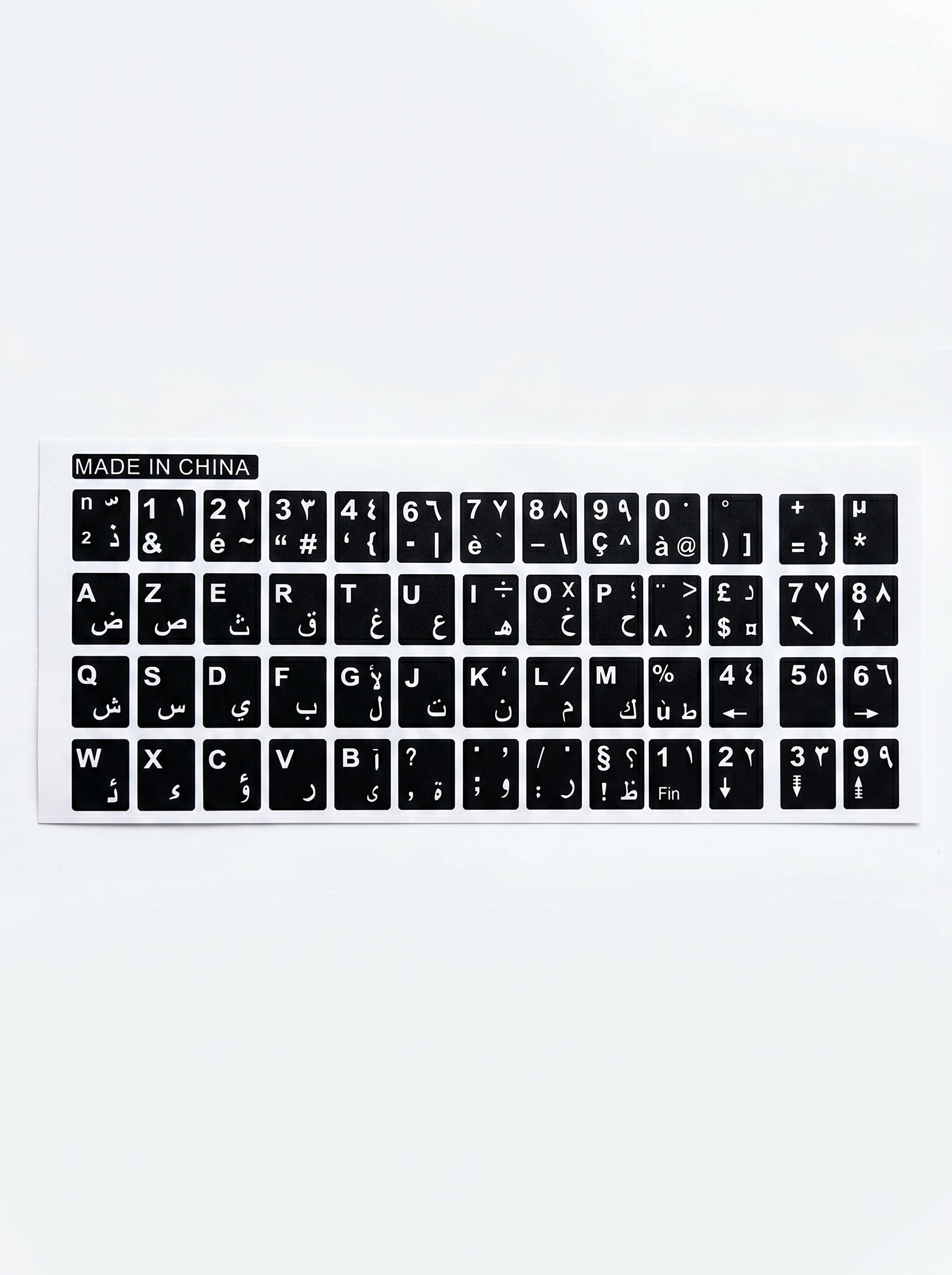 Plan rapproché sur des stickers clavier arabe et AZERTY appliqués sur un ordinateur portable.