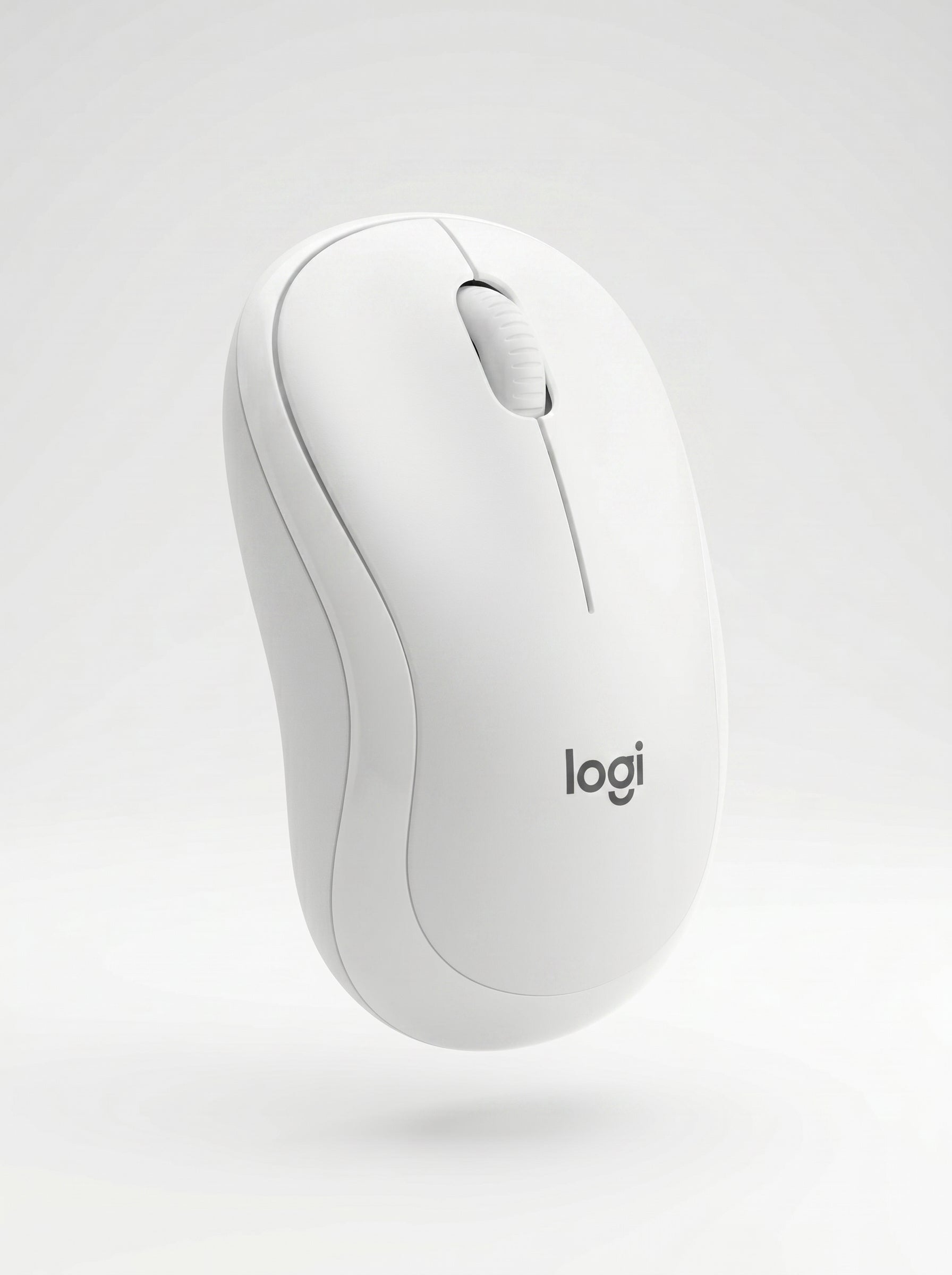 Souris Logitech Bluetooth silencieuse posée sur un bureau en bois lors d'une session de télétravail.