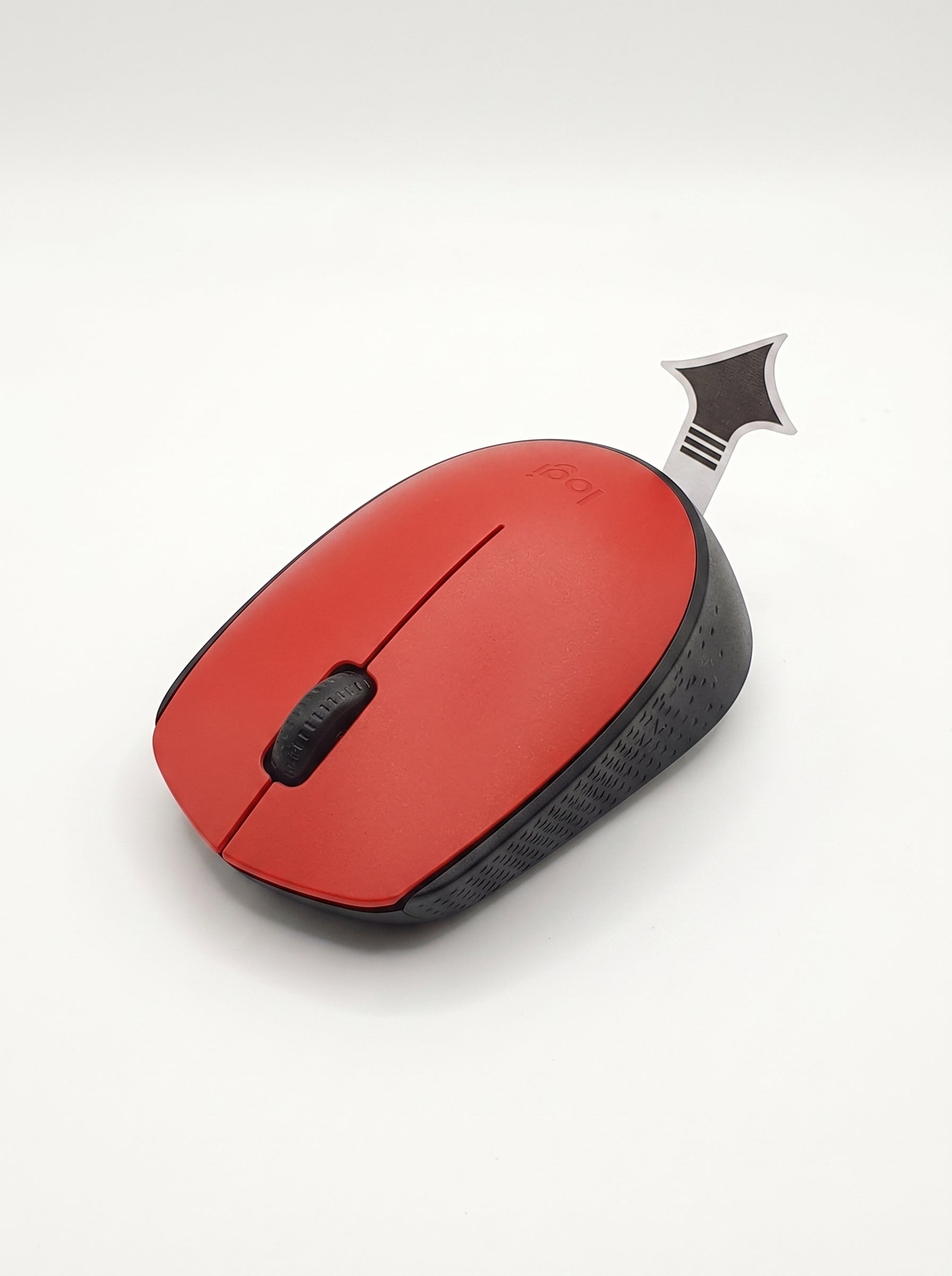 Souris sans fil compacte Logitech noire à côté d'un ordinateur portable sur une table de café.
