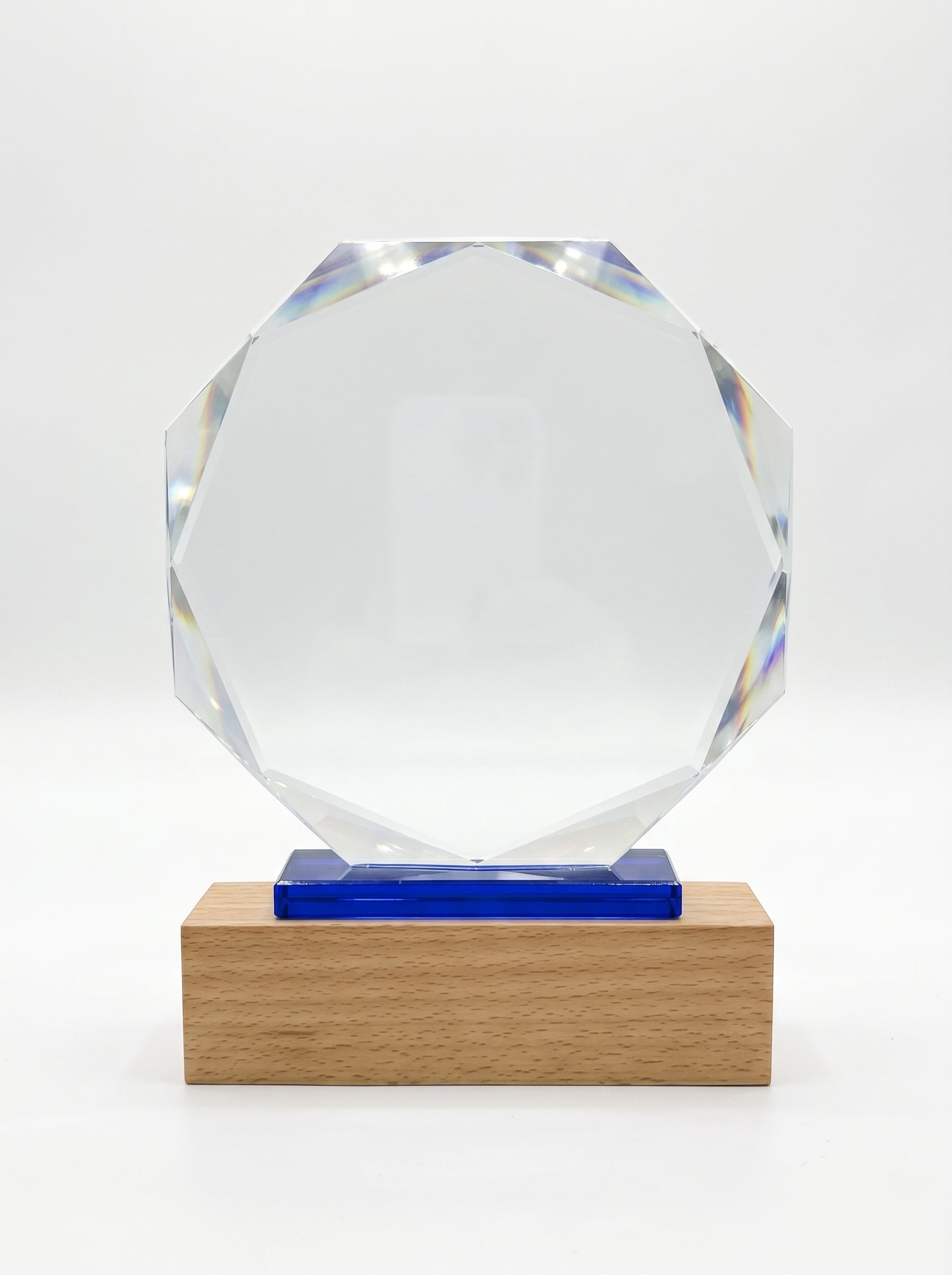 Trophée d'entreprise en verre de forme octogonale avec insert bleu et socle en bois massif clair.