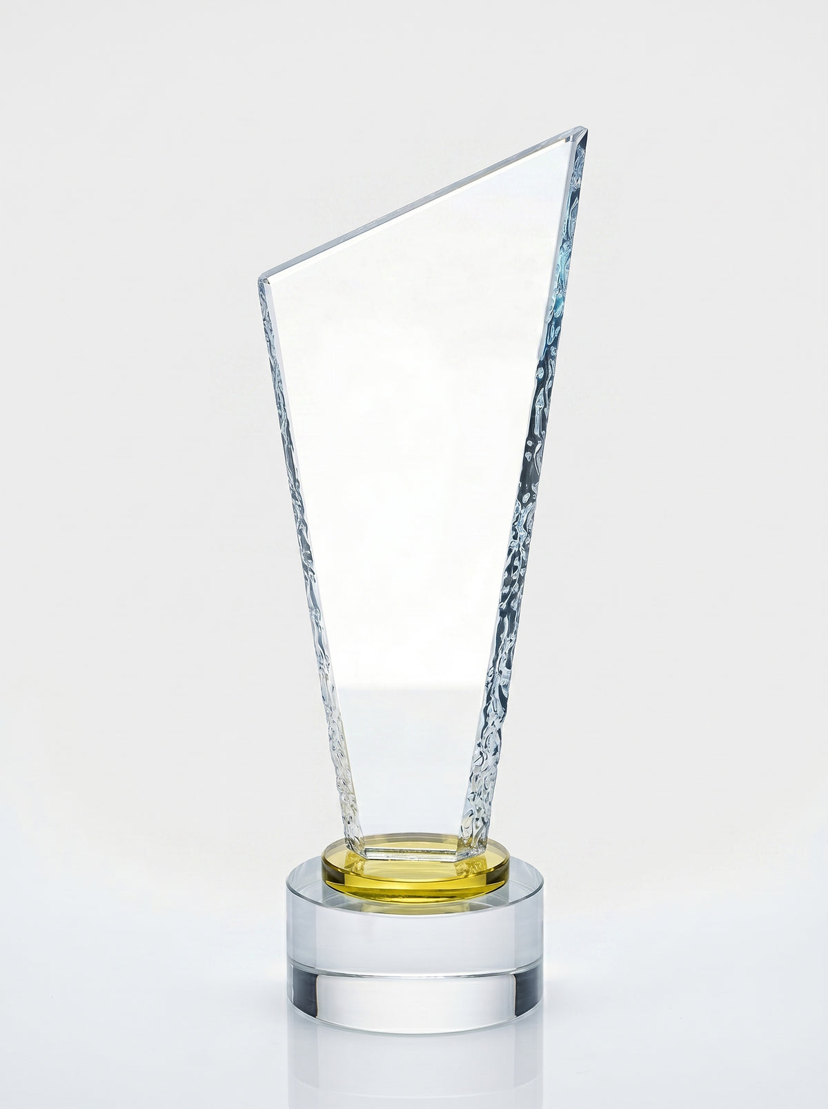 Trophée en verre épuré avec base ronde et anneau doré, idéal comme trophée de bureau.