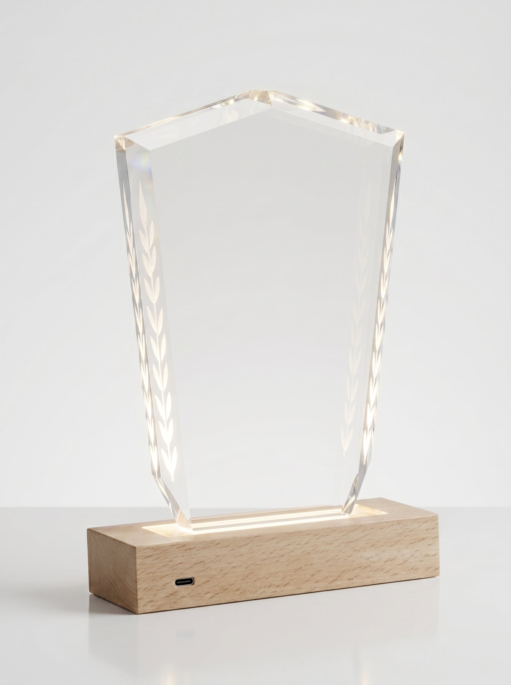 Trophée en verre lumineux sur socle en bois clair avec éclairage LED, idéal pour une récompense entreprise personnalisée.