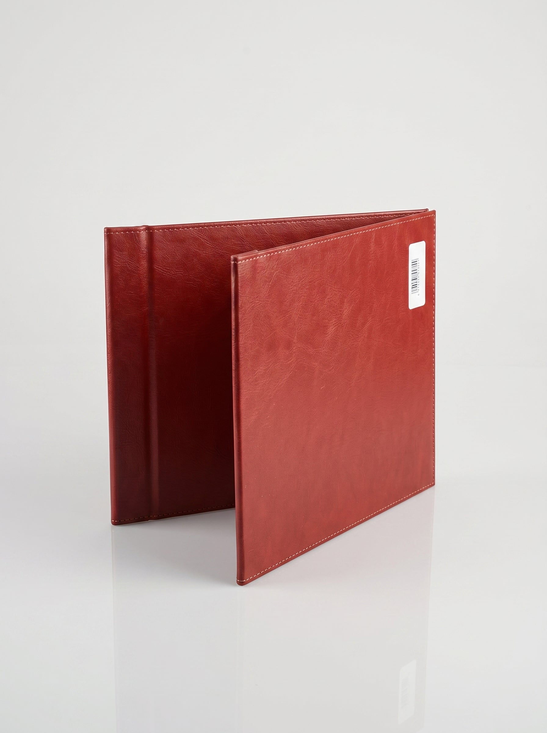 Porte-certificat A4 en similicuir rouge profond, ouvert sur un bureau.