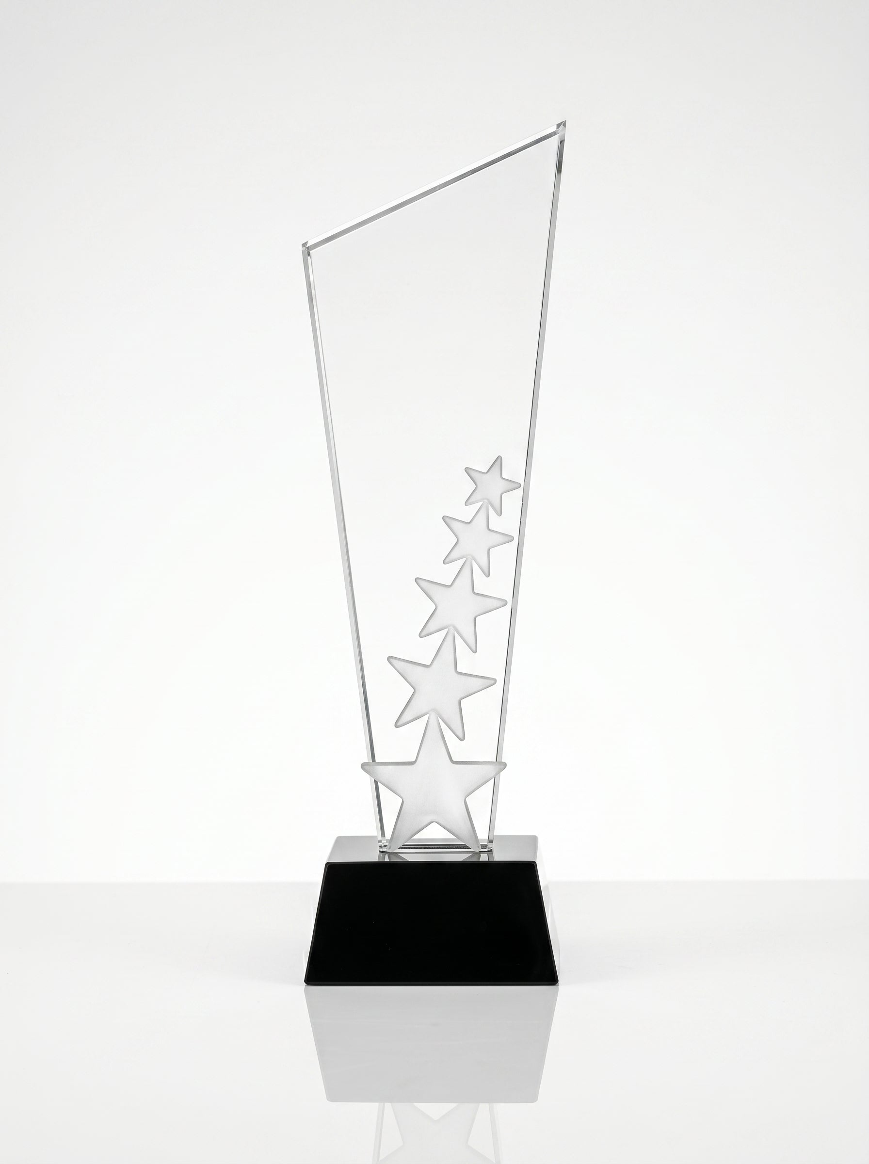 Trophée en verre épuré et récompense cristal posé sur un bureau de direction.