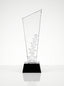 Trophée en verre épuré et récompense cristal posé sur un bureau de direction.