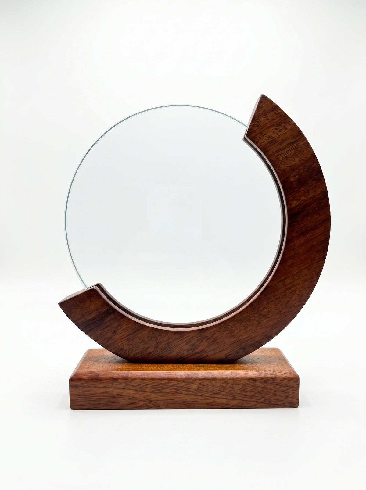 Trophée verre et bois au design circulaire avec cadre en croissant sur un bureau